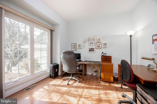 office featuring visible vents, wood finished floors, a wealth of natural light, and baseboards