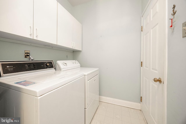 laundry area with baseboards, cabinet space, and washing machine and clothes dryer