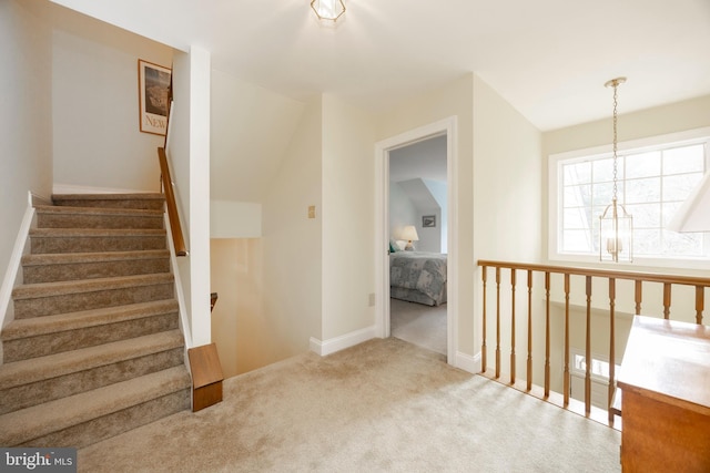 stairway featuring carpet flooring and baseboards