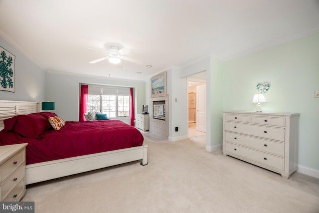 bedroom featuring baseboards, ornamental molding, a tiled fireplace, and light colored carpet