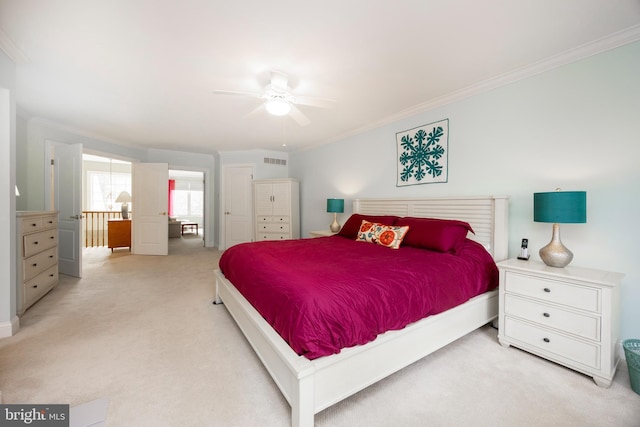 bedroom with a ceiling fan, light colored carpet, crown molding, and visible vents