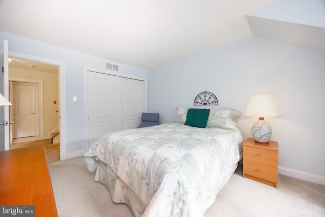 bedroom featuring light carpet, baseboards, visible vents, lofted ceiling, and a closet