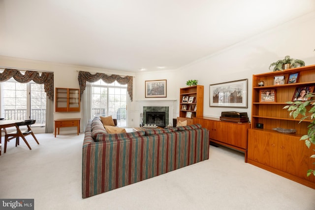 living area with a tile fireplace, crown molding, and light colored carpet