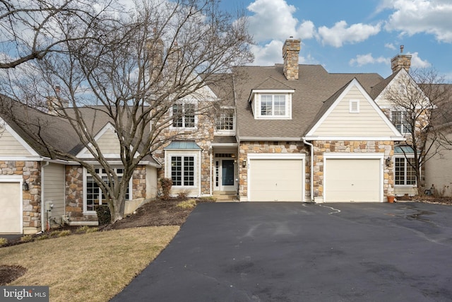 view of front facade with a garage, driveway, and roof with shingles