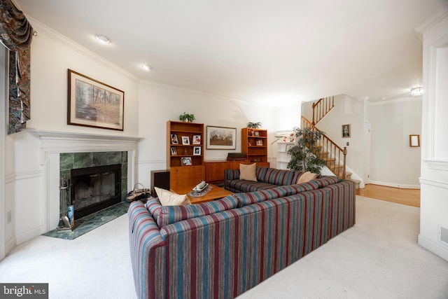 living room with baseboards, stairway, a tile fireplace, and crown molding