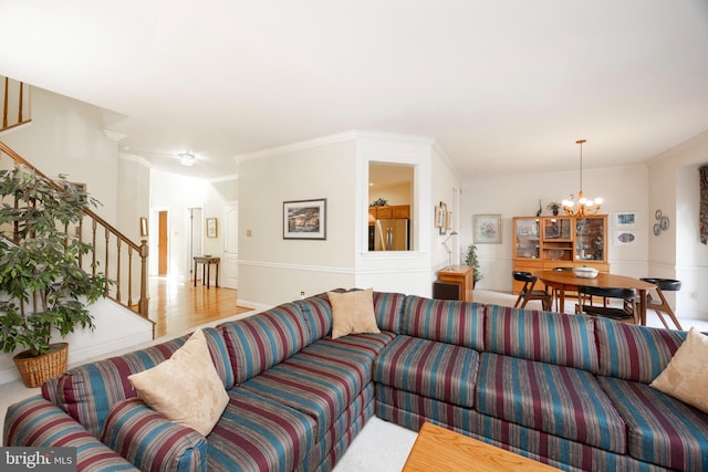 living area featuring stairs, a chandelier, wood finished floors, and ornamental molding