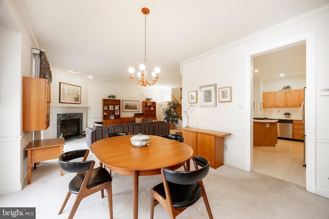 dining area with an inviting chandelier, ornamental molding, a high end fireplace, light carpet, and baseboards