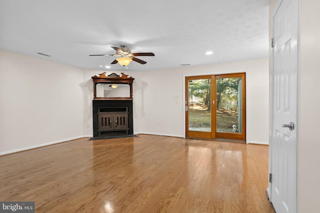 unfurnished living room featuring a ceiling fan, baseboards, visible vents, and light wood finished floors