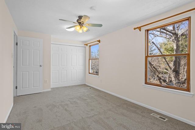 unfurnished bedroom featuring a closet, carpet flooring, visible vents, and baseboards