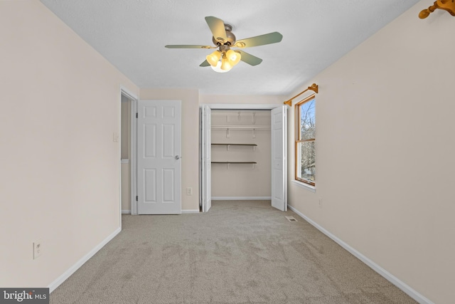 unfurnished bedroom featuring ceiling fan, carpet floors, a closet, and baseboards