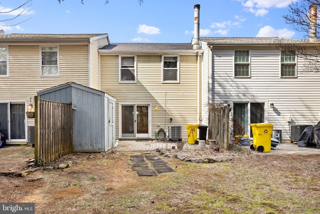 back of property with a storage unit, central AC, and an outdoor structure