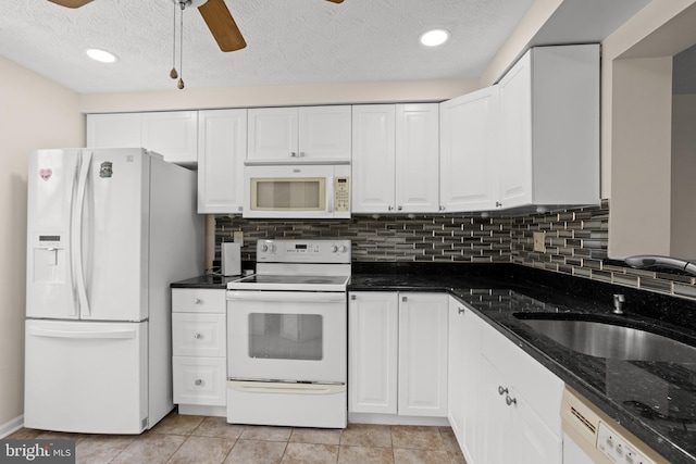 kitchen with white appliances, tasteful backsplash, white cabinets, ceiling fan, and a sink