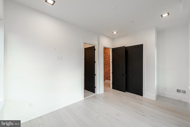 empty room with recessed lighting, visible vents, light wood-style flooring, and baseboards