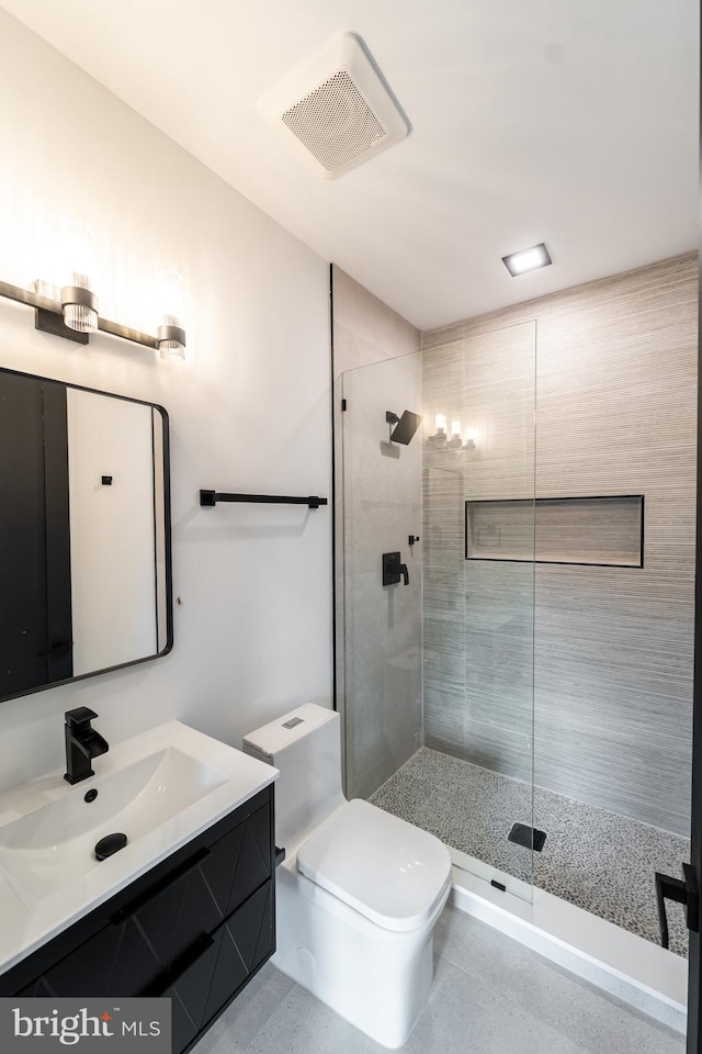 bathroom with toilet, a stall shower, vanity, and visible vents