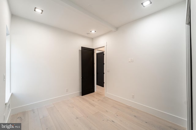 empty room featuring light wood-style floors, baseboards, beam ceiling, and recessed lighting