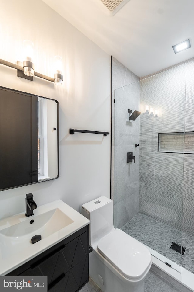 full bathroom featuring toilet, visible vents, tiled shower, and vanity