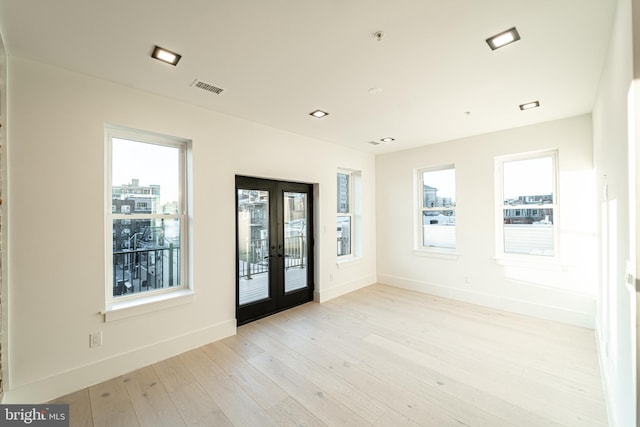 foyer with a wealth of natural light, french doors, visible vents, and light wood-style floors