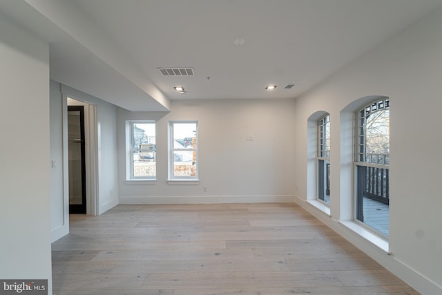 empty room with baseboards, visible vents, and light wood-style floors