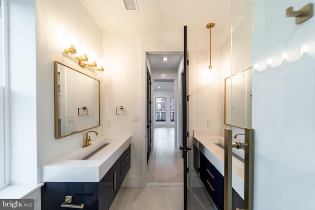 bathroom with wood finished floors, vanity, and visible vents