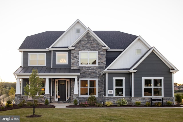 craftsman-style home with a standing seam roof, a front lawn, and board and batten siding