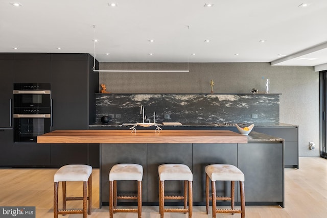 2510 Virginia Ave NW Unit 512-S, Washington, DC 20037 - kitchen featuring light wood-type flooring, modern cabinets, a breakfast bar area, and a spacious island