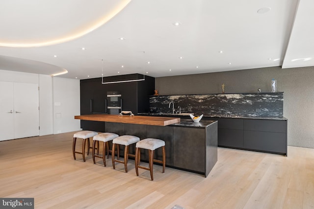 2510 Virginia Ave NW Unit 512-S, Washington, DC 20037 - kitchen featuring modern cabinets, light wood-type flooring, a large island, a kitchen bar, and butcher block countertops