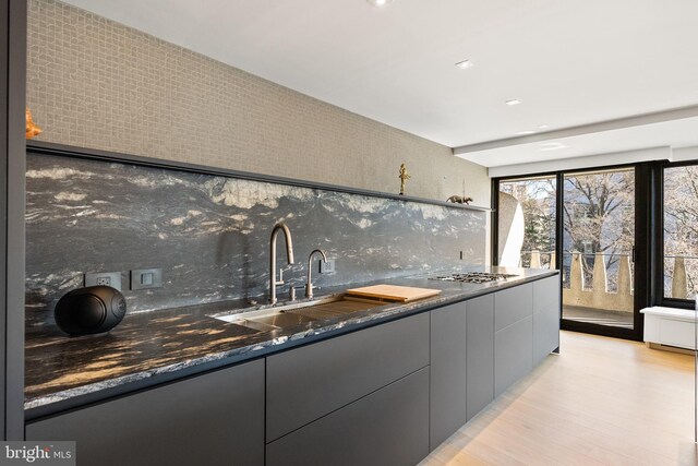 2510 Virginia Ave NW Unit 512-S, Washington, DC 20037 - kitchen featuring tasteful backsplash, stainless steel gas stovetop, gray cabinetry, light wood-style flooring, and modern cabinets