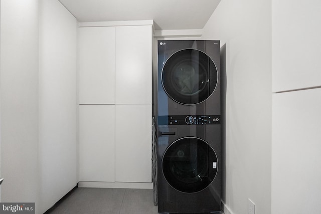 2510 Virginia Ave NW Unit 512-S, Washington, DC 20037 - laundry area with stacked washer / drying machine, tile patterned floors, and cabinet space