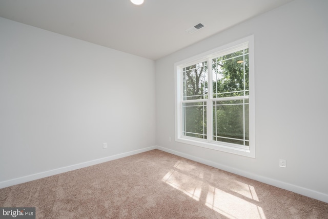 carpeted empty room with baseboards and visible vents