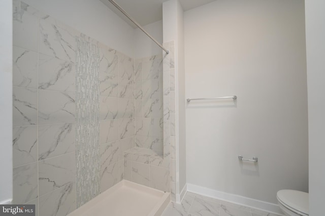 full bathroom featuring toilet, marble finish floor, a shower stall, and baseboards