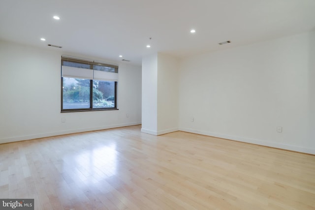 unfurnished room featuring recessed lighting, wood finished floors, and visible vents