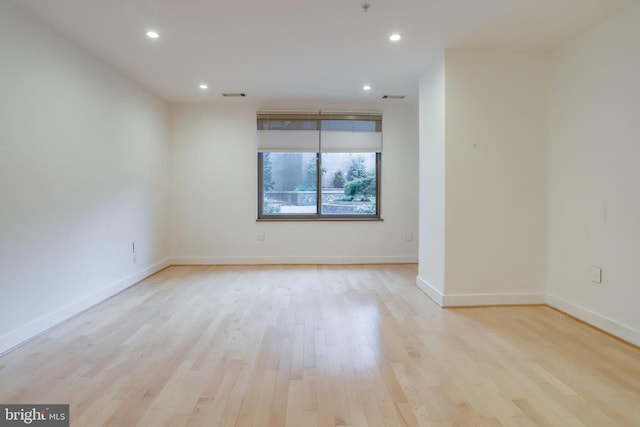 empty room with recessed lighting, visible vents, baseboards, and wood finished floors