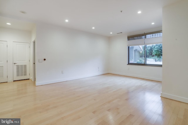 empty room featuring recessed lighting, visible vents, light wood finished floors, and baseboards