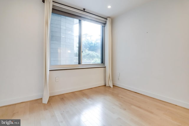 unfurnished room with recessed lighting, baseboards, and wood finished floors