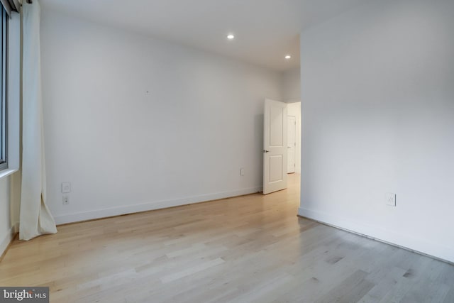 unfurnished room featuring recessed lighting, light wood-type flooring, and baseboards