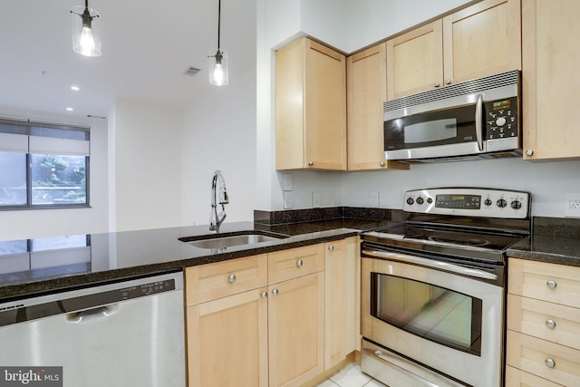 kitchen with light brown cabinetry, appliances with stainless steel finishes, and a sink