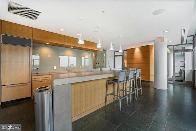 kitchen with light countertops, paneled built in fridge, modern cabinets, and visible vents