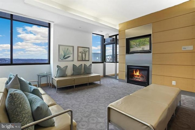 carpeted living area with a glass covered fireplace