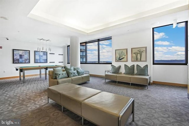 carpeted living room featuring baseboards, a raised ceiling, and billiards