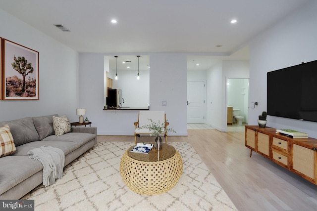 living room with visible vents, recessed lighting, baseboards, and light wood-style floors