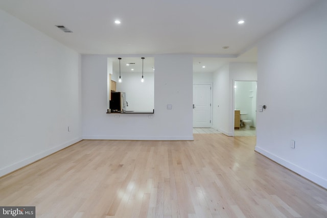 unfurnished living room with visible vents, recessed lighting, baseboards, and light wood finished floors