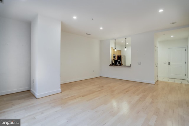 unfurnished living room with visible vents, light wood-style flooring, recessed lighting, and baseboards