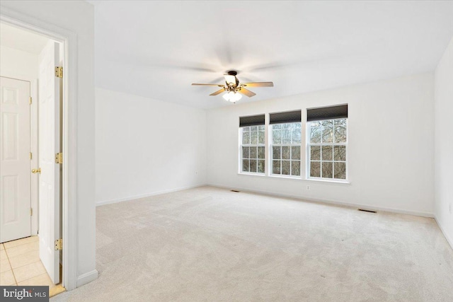 unfurnished room featuring a ceiling fan, carpet, visible vents, and baseboards