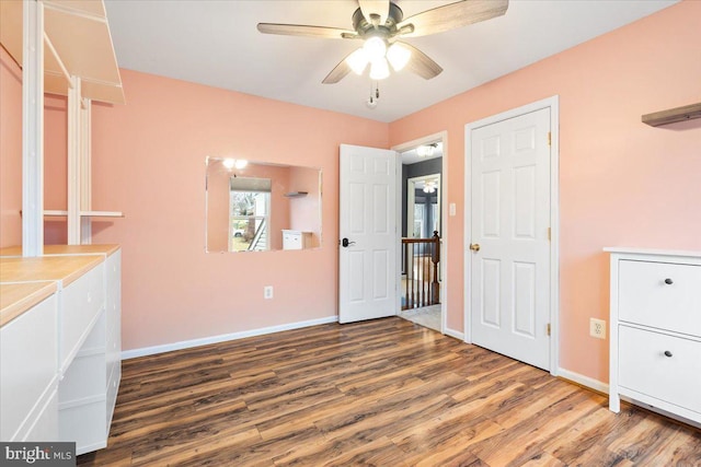 unfurnished bedroom with a ceiling fan, baseboards, and wood finished floors