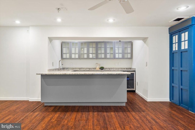 kitchen featuring dark wood-style floors, beverage cooler, glass insert cabinets, and a peninsula