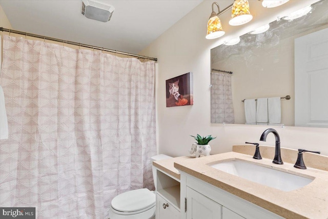 bathroom featuring toilet, visible vents, and vanity