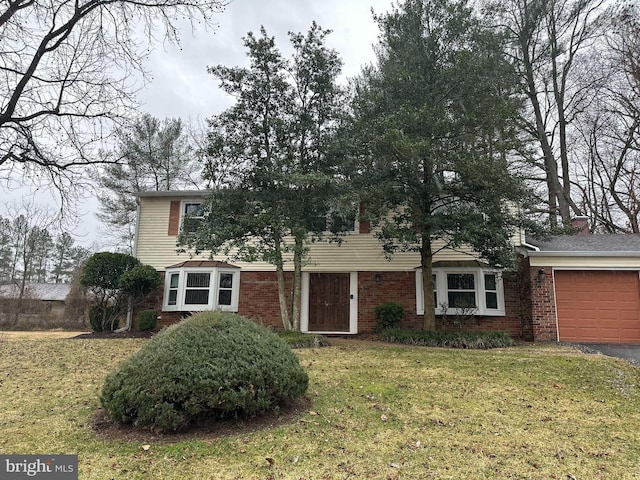 traditional-style home featuring a garage, driveway, brick siding, and a front yard