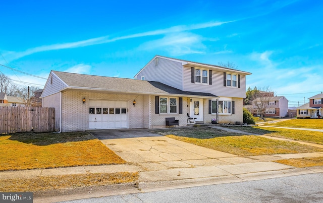 view of front of home with brick siding, fence, a garage, driveway, and a front lawn