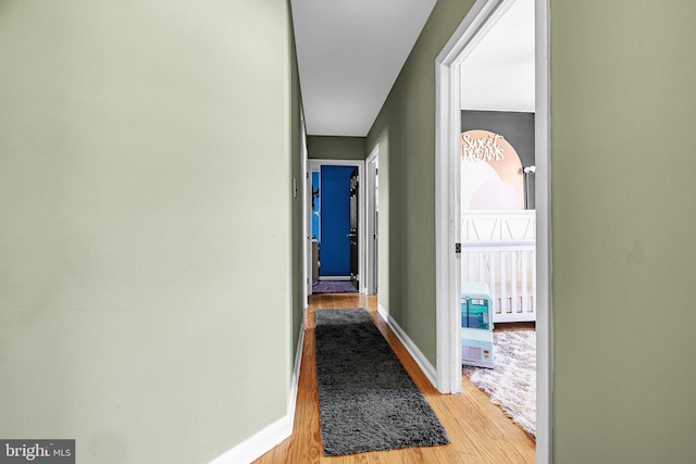 hall with light wood finished floors and baseboards