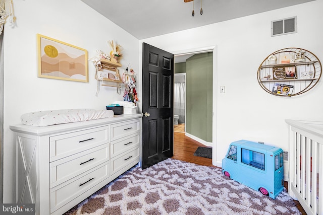 bedroom featuring visible vents, baseboards, and wood finished floors